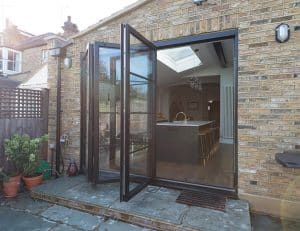 An open black aluminium bifold door